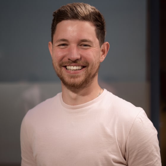 Alex Bates - Associate Director of Relish. A man with short dark brown hair and short beard, smiling